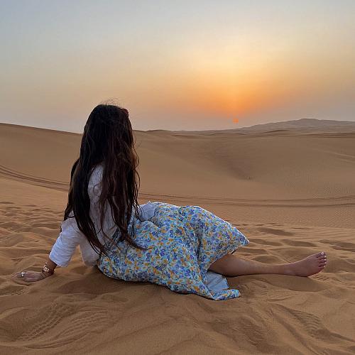 Ariana lounging in the sand in the United Arab Emirates.