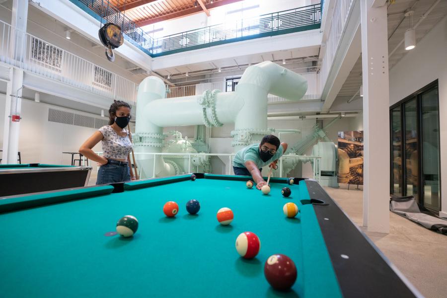 Students playing pool in the lower level of the Powerhouse.
